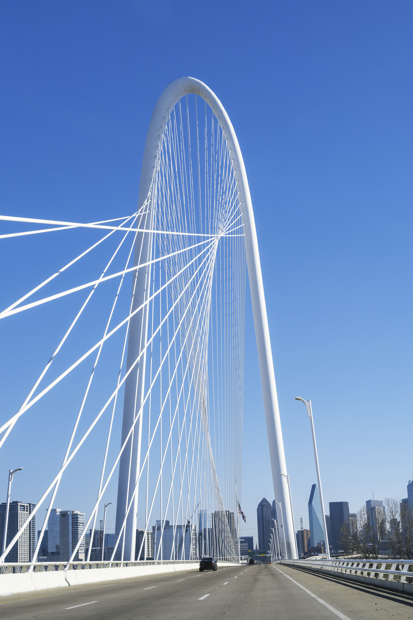 Recruiting Agencies Dallas - Margaret Hunt Hill Bridge with the clear blue sky and Dallas City downtown skyline in the background, cityscape from the highway over the Trinity River in Texas, USA